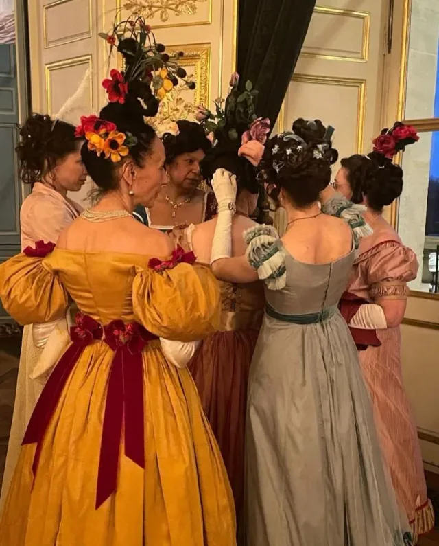 Femmes en robes historiques et coiffures hautes ornées de rubans