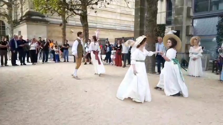 Couples en costumes historiques dansant devant le public dans les jardins de l’Hôtel de Rohan